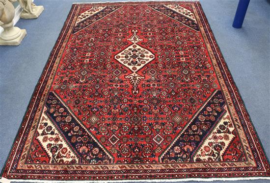 A Hamadan red and blue ground rug, 9ft 9in by 6ft 7in.